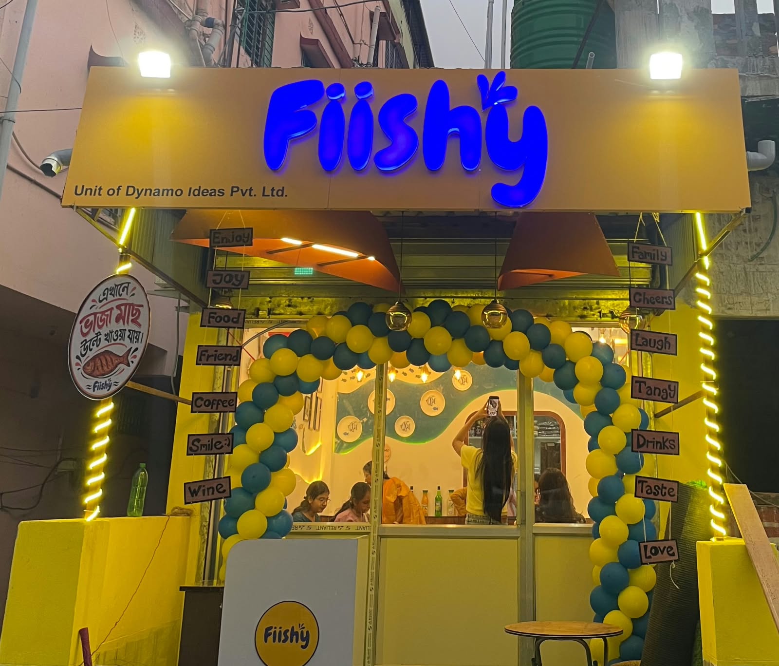 The shopfront by the day, a board with yellow colour and blue fiishy logo